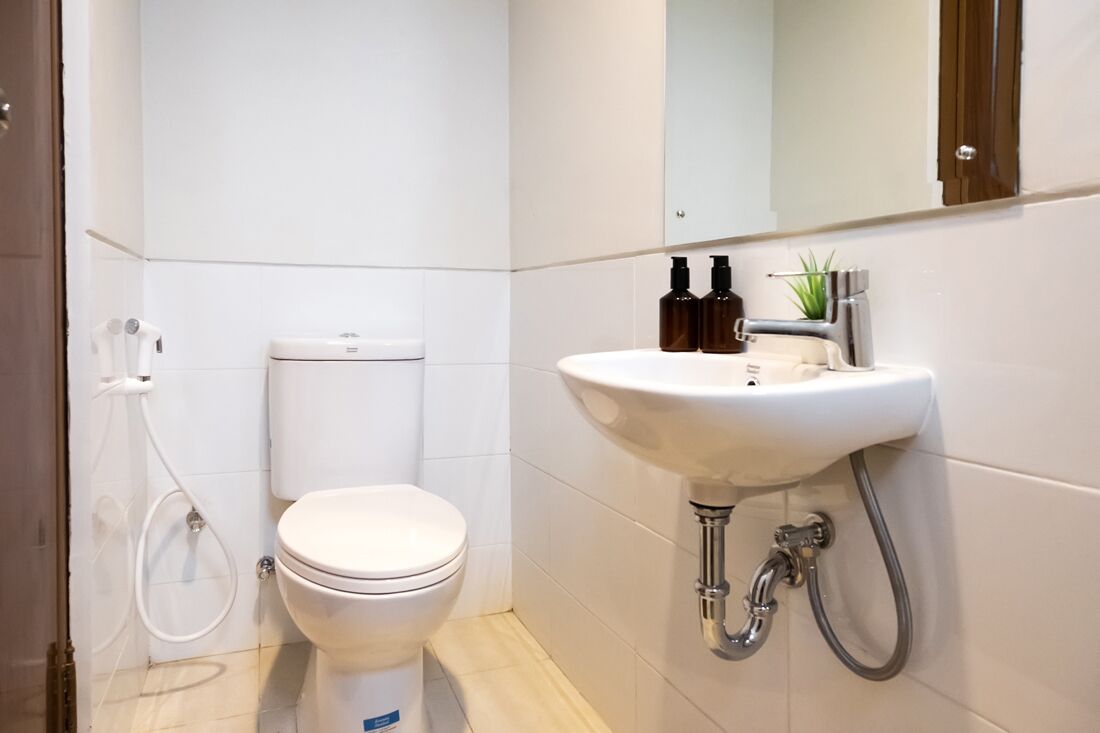 Moderni kylpyhuone, jossa on wc, pesuallas ja suihku.