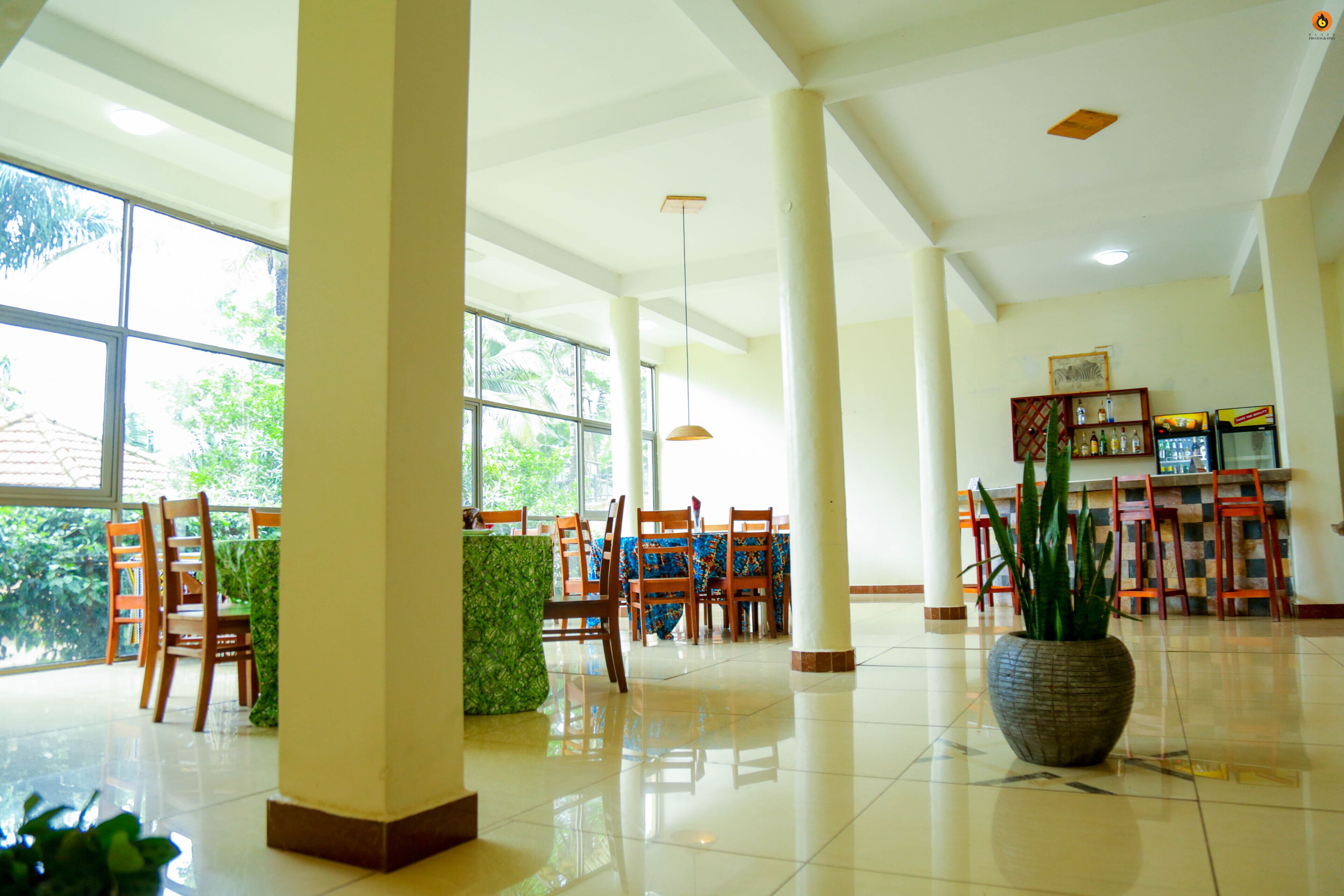 A spacious lobby with high ceilings, large windows, and a central seating area with chairs and a table.
