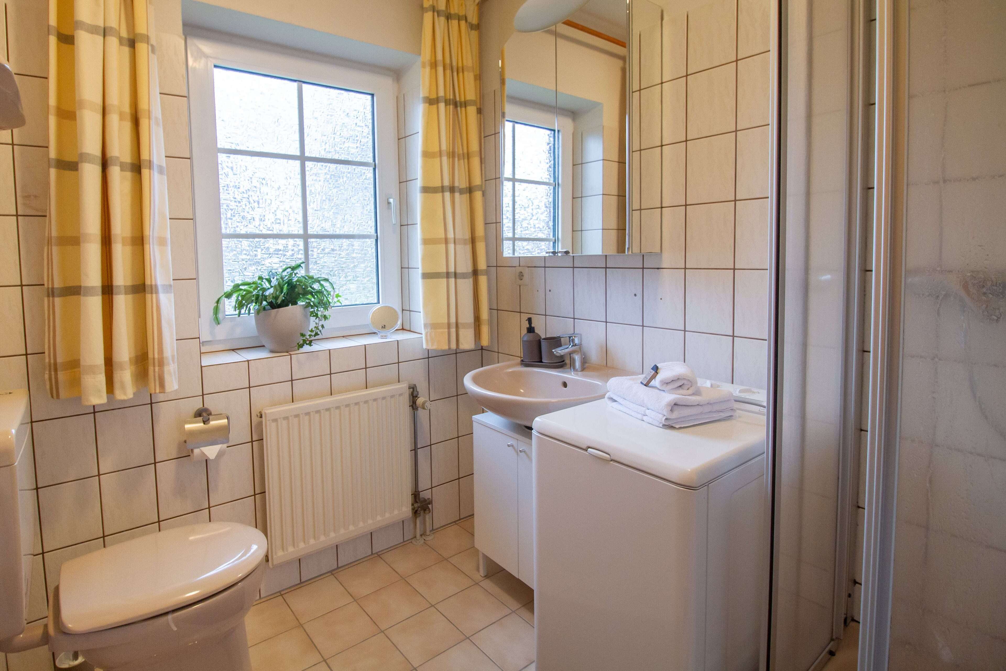 Une salle de bain avec des toilettes, un lavabo et un miroir.