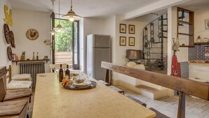 A kitchen with a large island, a refrigerator, and a dining area with chairs. - 'Torre del Falco', a wonderful medieval tower in Spoleto (Spoleto)