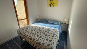 Une chambre à coucher avec un lit, une fenêtre et un tableau accroché au mur.