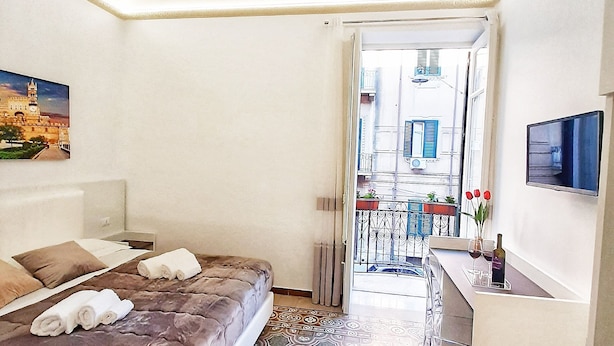 Ein Hotelzimmer mit Bett, Schreibtisch und Fernseher.