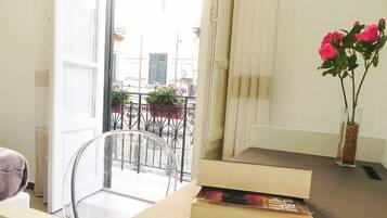 Ein Zimmer mit einem Glastisch, einem Stuhl, einer Vase mit Blumen und einem Buch auf dem Tisch.