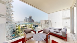 Een balkon met uitzicht op een stadshemelbeeld en een wateroppervlak.