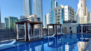 A rooftop pool with a cityscape view, including high-rise buildings and a clear sky. - Elegant 1 Bed l Dubai Marina l City Skyline View I Studio One Tower (Dubai Marina)