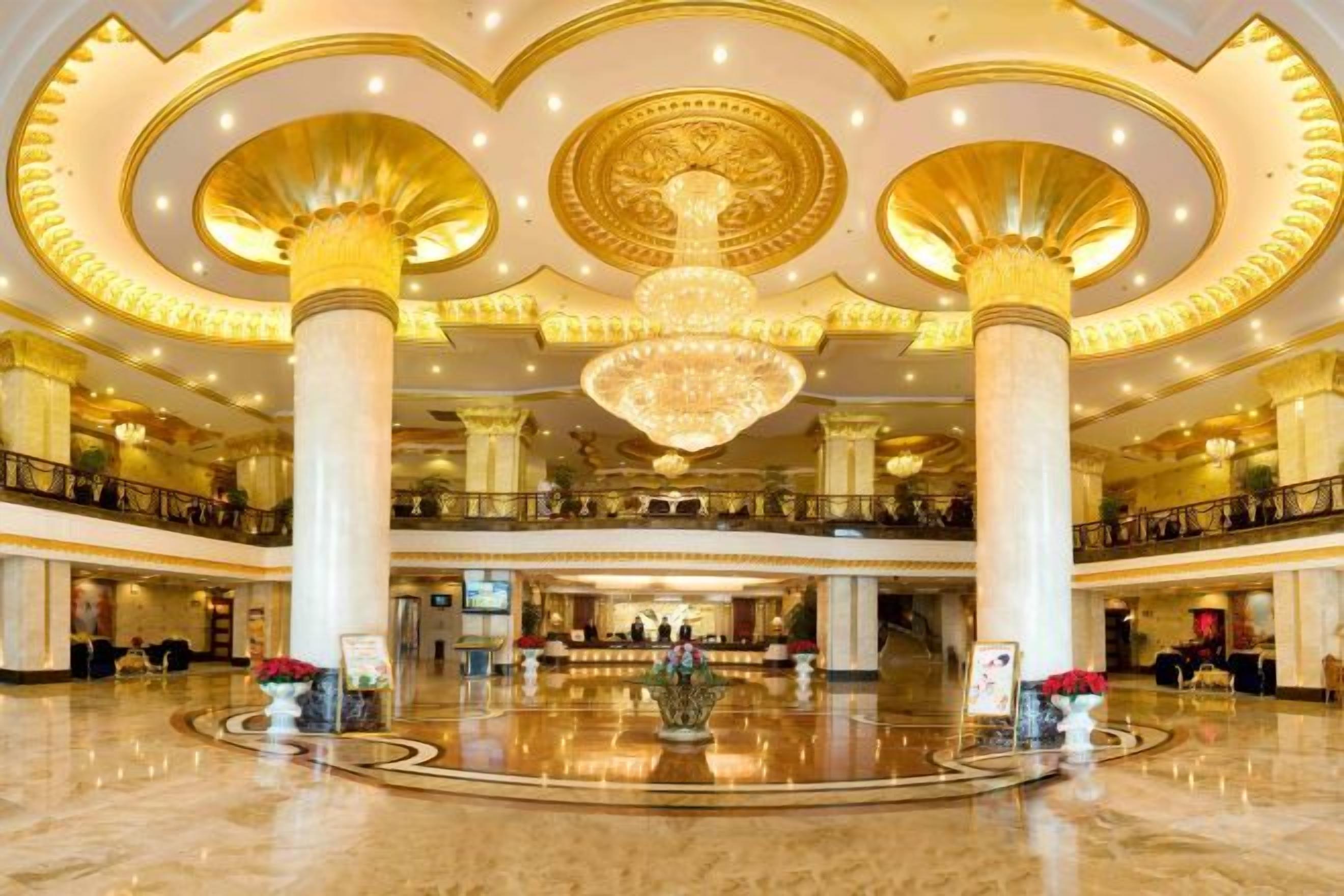 A spacious lobby with a grand chandelier, multiple levels, and a central column.