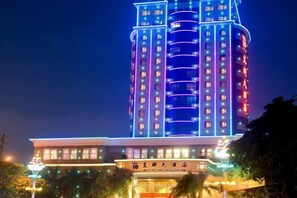 Ruang Duig Hotel features modern architecture with balconies and windows, surrounded by lush greenery.