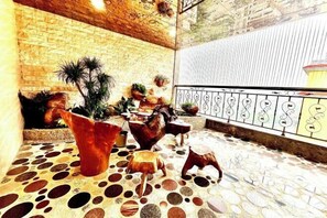 A courtyard with a stone floor, potted plants, and a wrought iron railing. - Huang Du Big Hotel (Shantou)