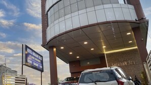 Um hotel com fachada de vidro moderna, uma placa anunciando quartos, banquetes e um restaurante.