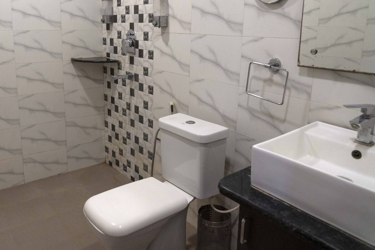 Un baño con inodoro, lavamanos y paredes con azulejos.
