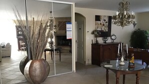 A dining area with a round table, a large mirror, and a chandelier. - Pretty house with swimming pool in Périgord (Pazayac)