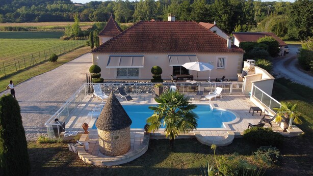 A villa with a swimming pool, outdoor seating, and a stone fountain. - Pretty house with swimming pool in Périgord (Pazayac)