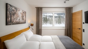 A hotel room with a bed, a painting, a window with curtains, and a door. - Auhof (Bad Gastein)