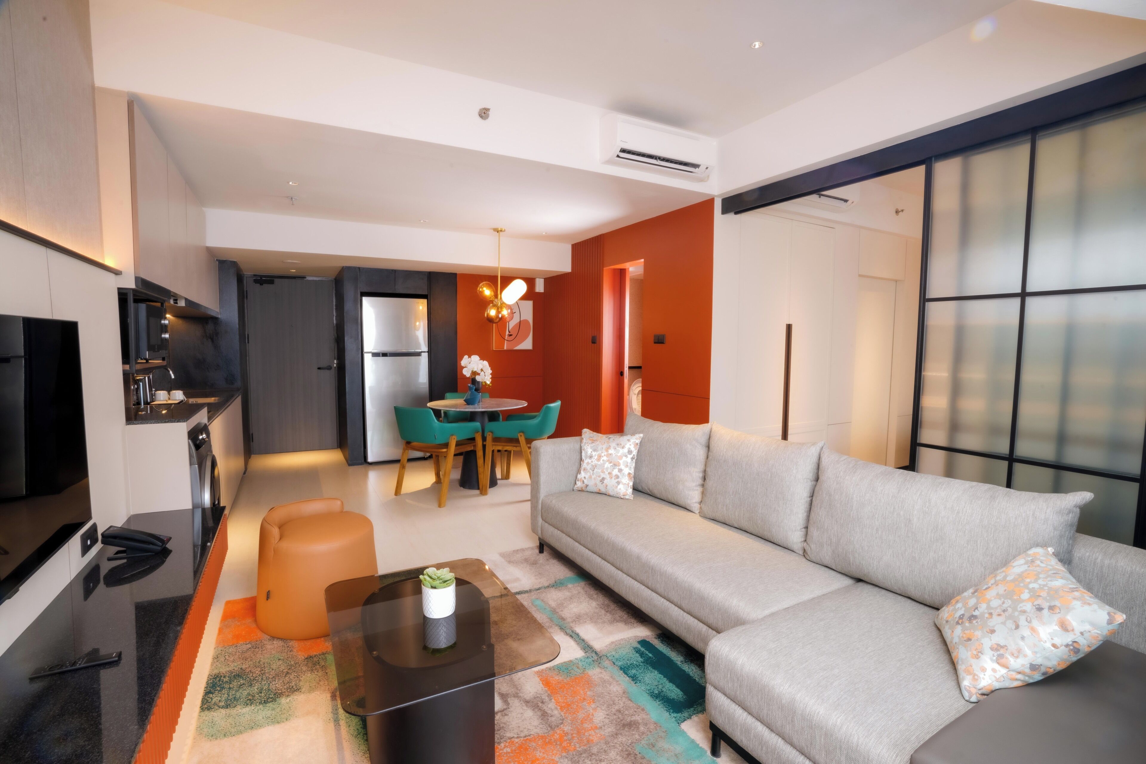 Una sala de estar moderna con un sofá, una mesa de centro y un comedor con sillas y una mesa.