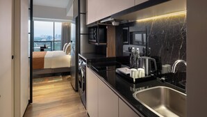 A modern kitchen with a built-in oven, microwave, and stainless steel sink. - Herloom BSD (Gading Serpong)