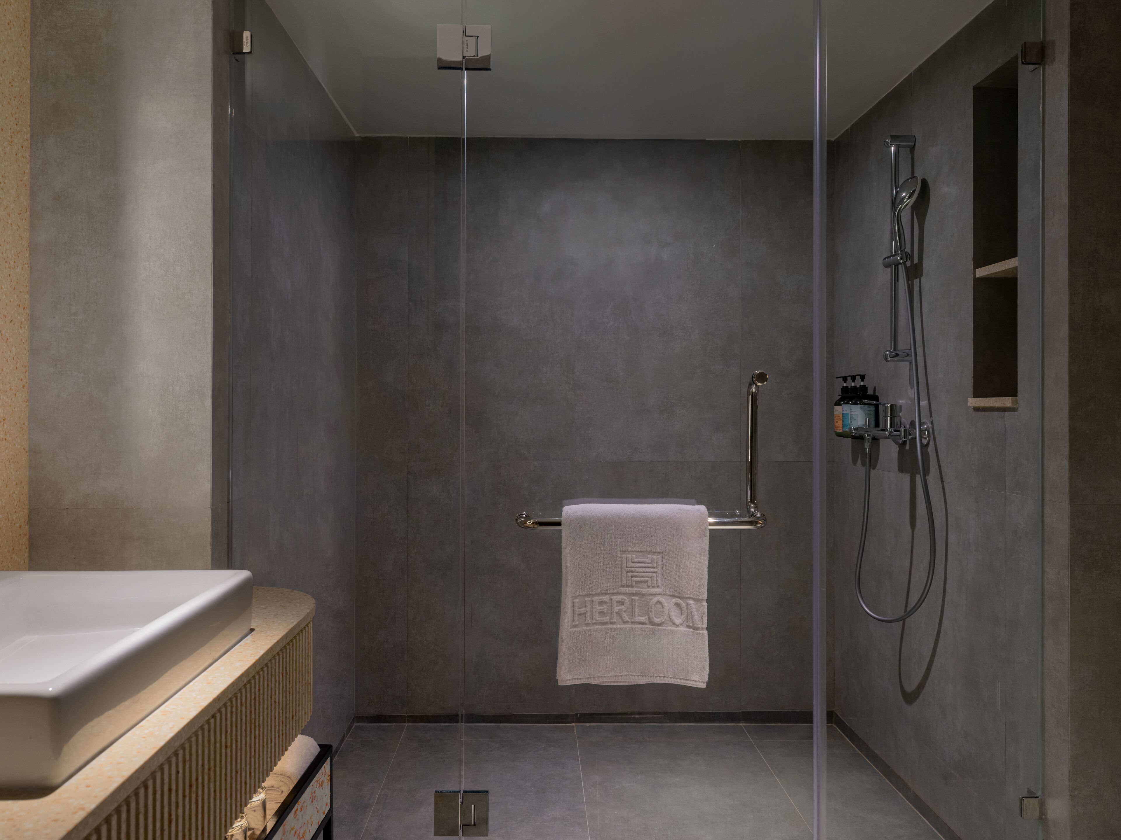 A modern bathroom with a shower, a towel rack with a towel, and a radiator.