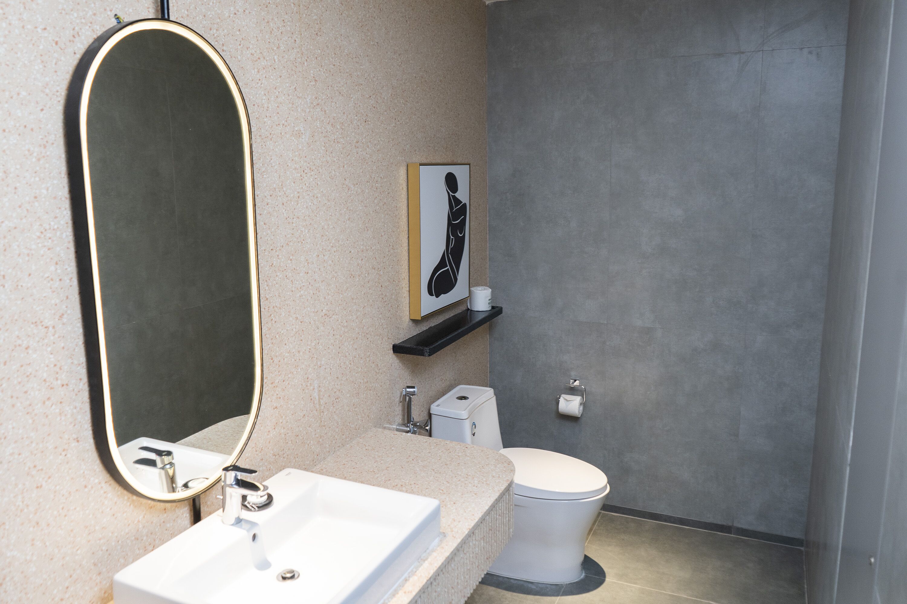 A bathroom with a white sink, a toilet, and a mirror.