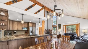 Una cocina amplia con una isla grande, armarios de madera y un comedor con mesa y sillas de madera.