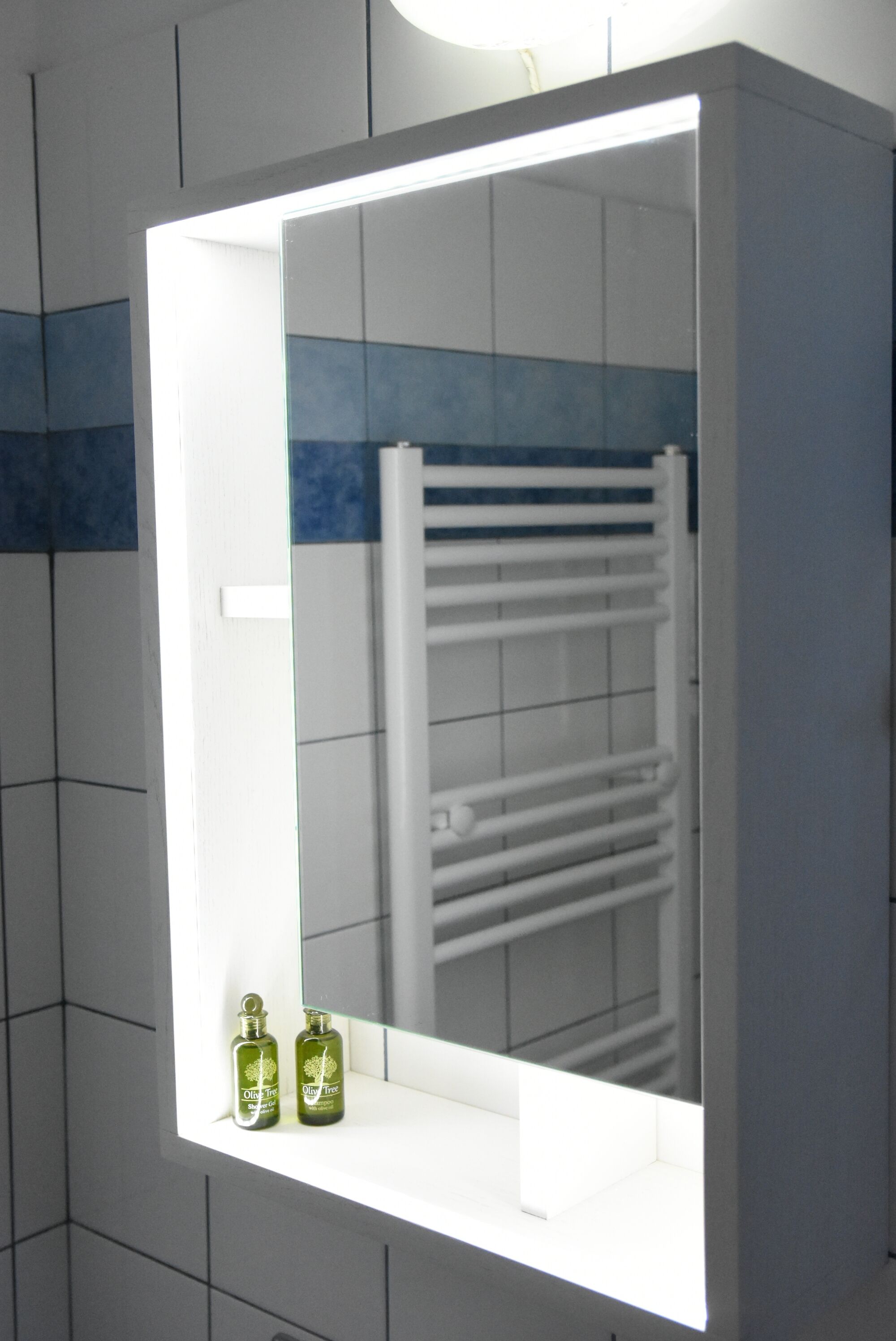 Une salle de bain avec un miroir, un porte-serviettes et deux flacons de lotion.