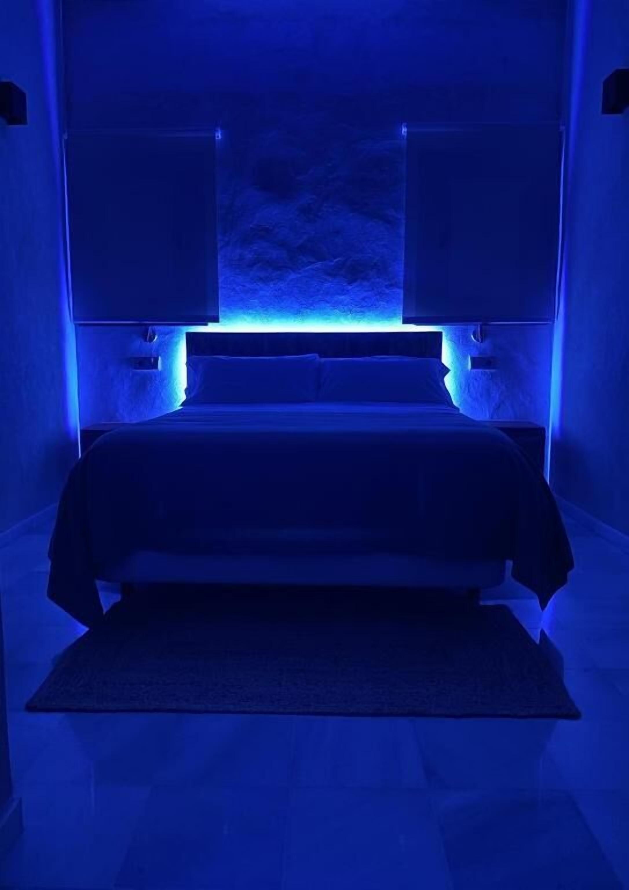 Una camera da letto con un letto, un comodino e una mensola a parete.