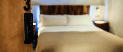 Una habitación de hotel con una cama, una mesita de noche y una puerta con el número 3.