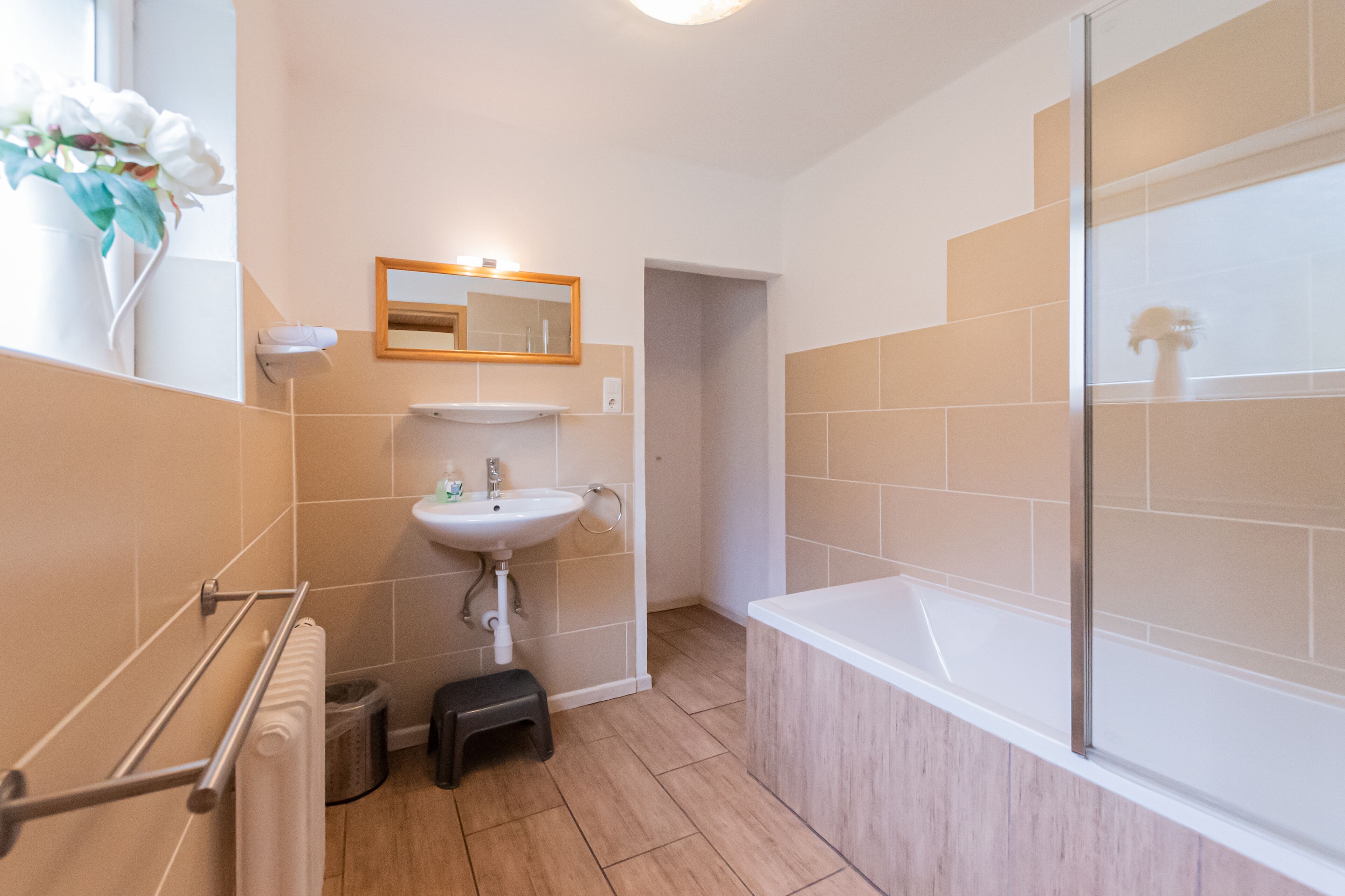 Ein modernes Badezimmer mit Waschbecken, Spiegel und Dusche.