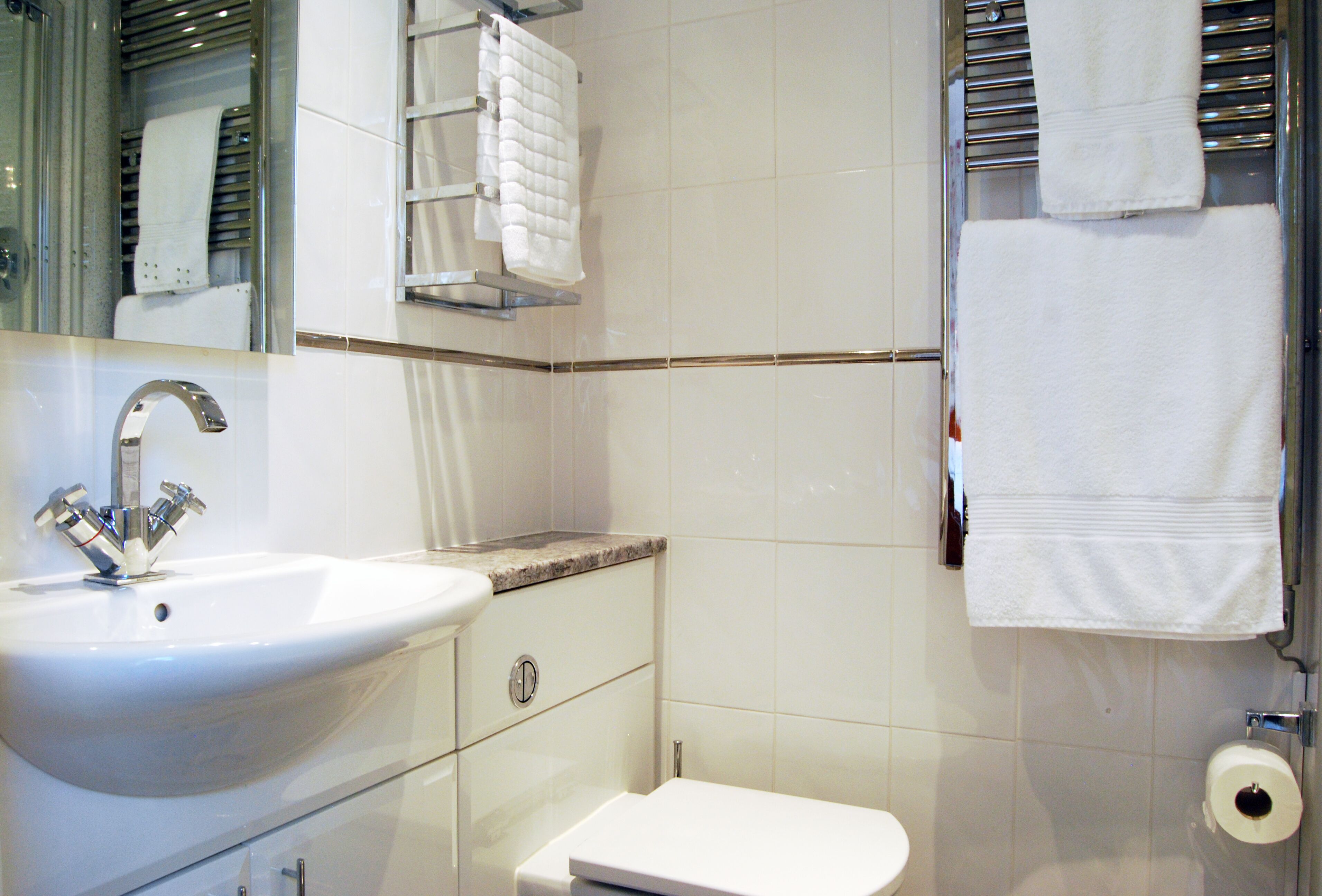 A bathroom with a white sink, a toilet, and a mirror.