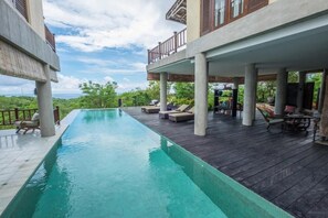 Una piscina al aire libre, tumbonas