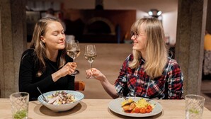 Two people at a table with plates of food and glasses of wine. - Hotel Prácheň (Horazdovice)