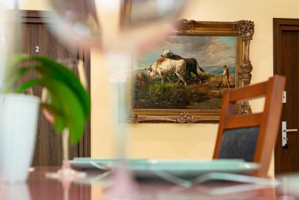 A painting of two cows and a person in a field, framed and hanging on a wall. - La Hacienda (Vilvoorde)