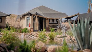 A desert-style building with a flat roof and a small water feature in the foreground. - Le Bedouin Agafay (Agafay)