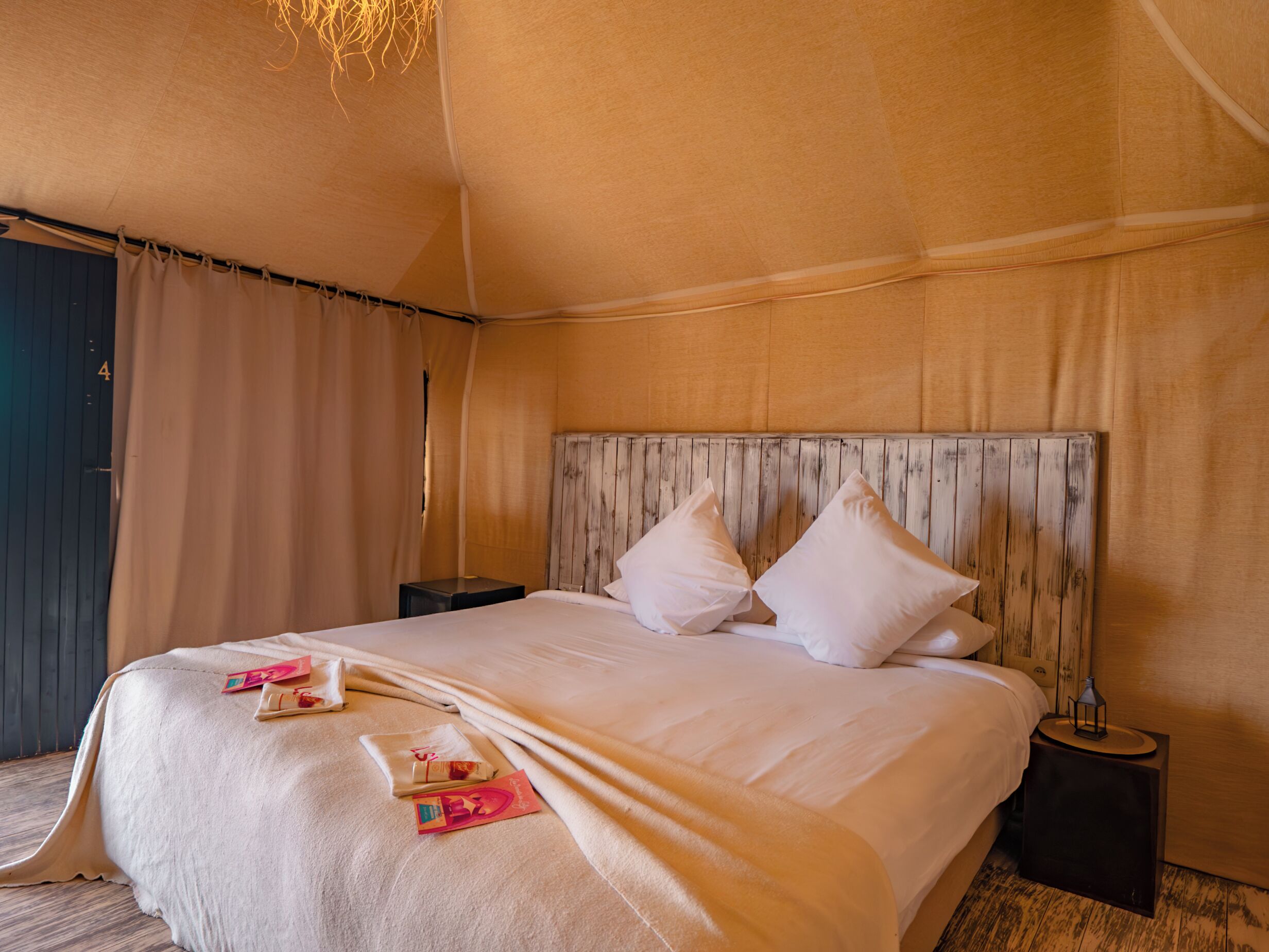 A spacious bed with a wooden headboard, a bedside table, and a nightstand.