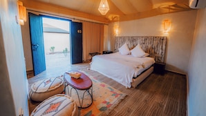 A spacious bedroom with a large bed, a wooden ceiling, and a view of the outdoors through a sliding door. - Le Bedouin Agafay (Agafay)