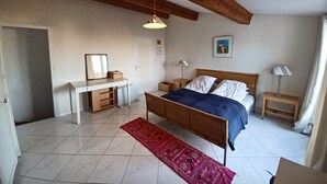 A bedroom with a bed, bedside tables, a desk, a chair, and a hanging light fixture. - Small oasis in the center of Céret (Céret)