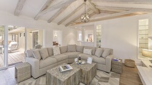 A modern living room with a large L-shaped sectional sofa, a wooden coffee table, and a chandelier. - 3877 Sea Esta~ Beautifully Remodeled, Near Golfing (Pebble Beach)