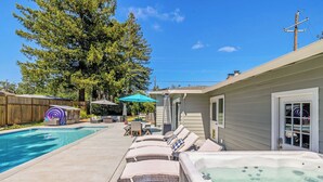 A backyard with a swimming pool, lounge chairs, a hot tub, and a wooden deck. - Wine Country Retreat w/ Pool, Hot Tub, Backyard & Game Nights Near Wineries (Santa Rosa)