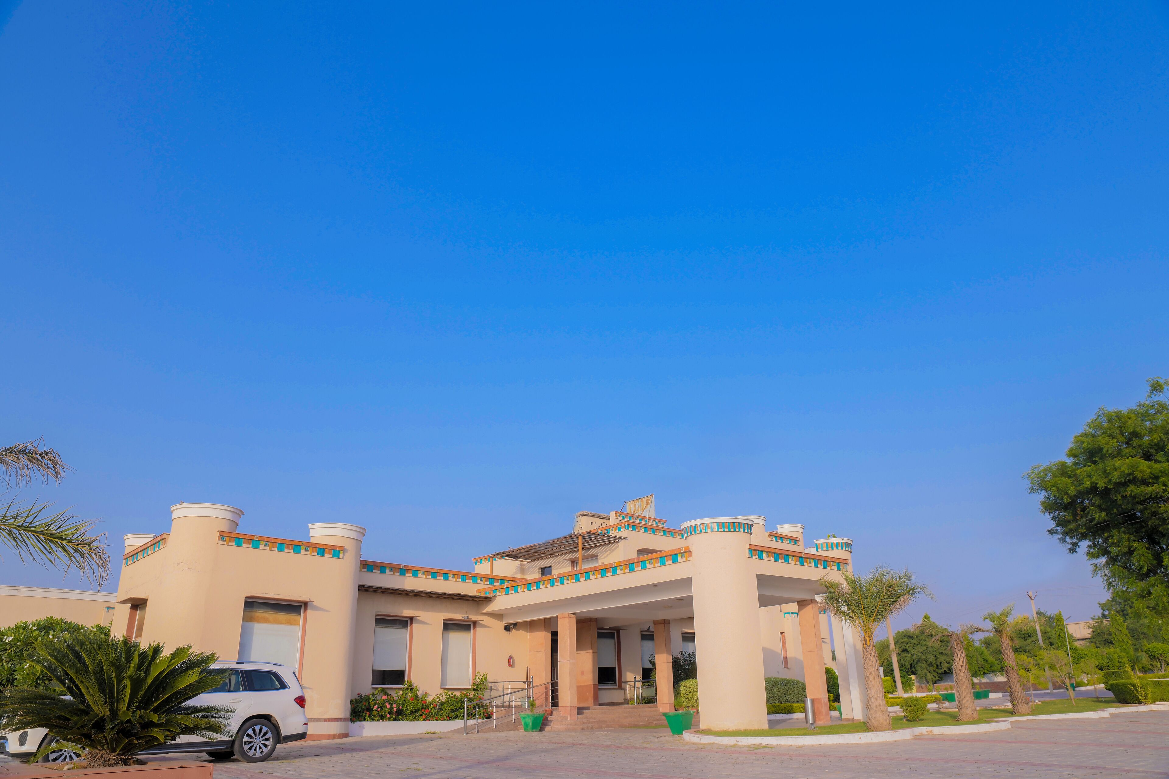 A modern building with a central courtyard, featuring a white car parked in front.