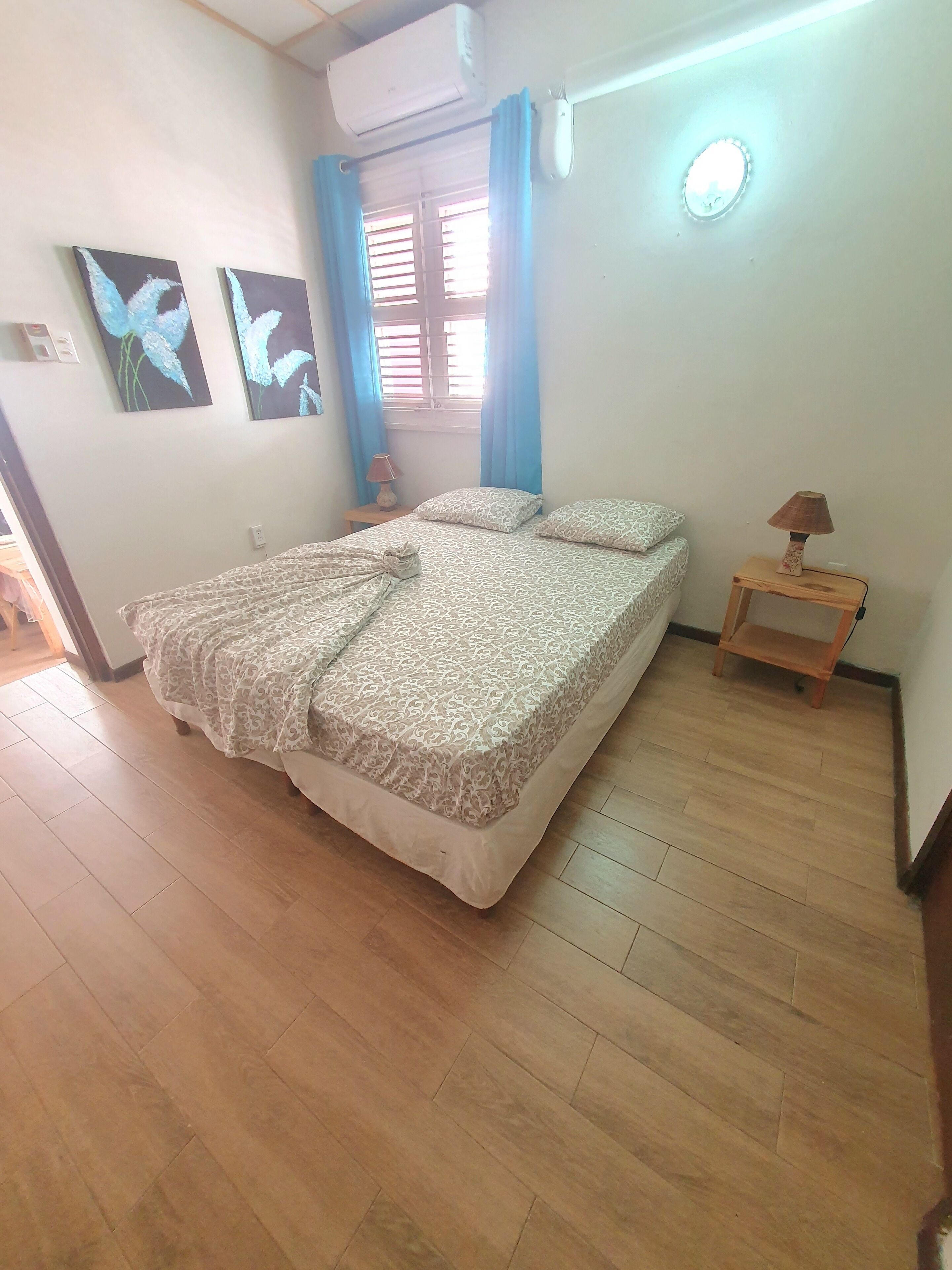 A bedroom with a bed, a nightstand, a lamp, and a ceiling fan.