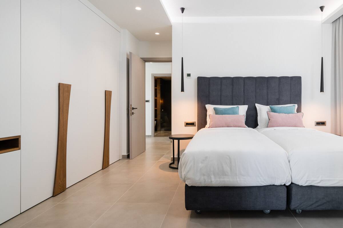 Un dormitorio moderno con una cama grande, un armario y una mesita.