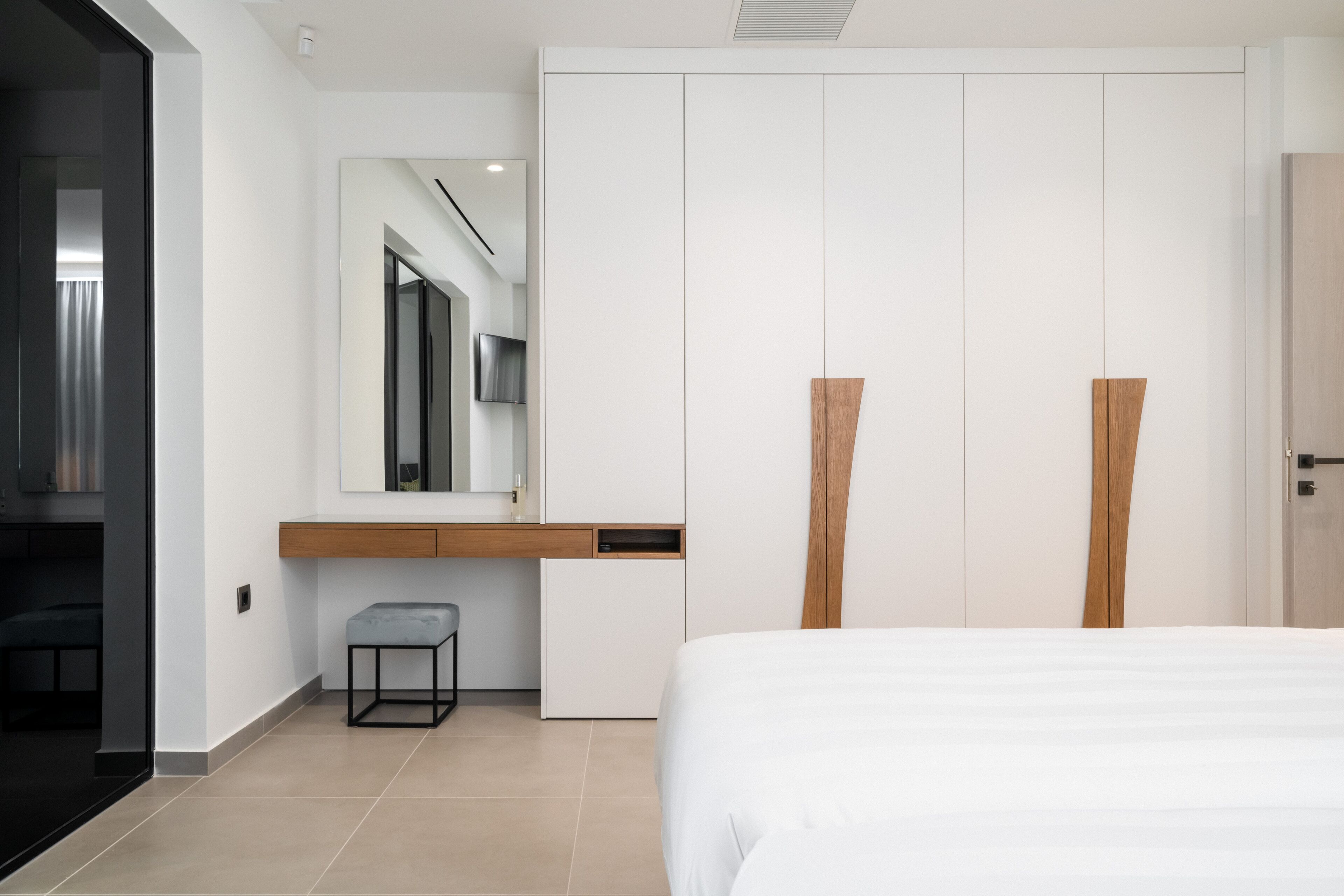 Quarto moderno com cama, escrivaninha, cadeira e guarda-roupa.