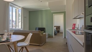 A modern hotel room with a dining area, a sofa, a bed, and a kitchenette. - Brignole de Ferrari - 401 by Wonderful Italy (Genova)