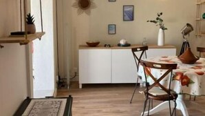 Uma cozinha acolhedora com armários de madeira, uma mesa de jantar com cadeiras e um lustre.