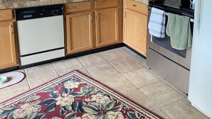A kitchen with wooden cabinets, a dishwasher, a microwave, and a stove. - Cozy cottage nestled in Paradise Valley surrounded by mountain views! (Livingston)