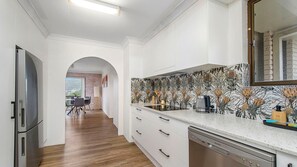 Eine moderne Küche mit weißen Schränken, einem Geschirrspüler und einer Rückwand mit Blumenfliesen.