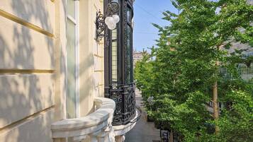 A narrow balcony with ornate black railings and a white balustrade.
