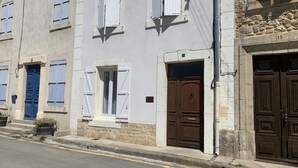 A row of buildings with white walls and blue shutters, featuring a stone wall with the number 19. - Logis de la Foulerie (Bize-Minervois)
