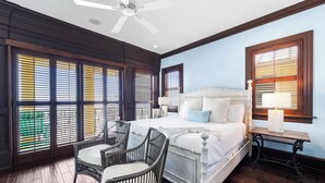A bedroom with a large bed, two chairs, a ceiling fan, and multiple windows with blinds. - The Brookie*OnBeach*BeachSvc*Elevator*2Pools (Miramar Beach)