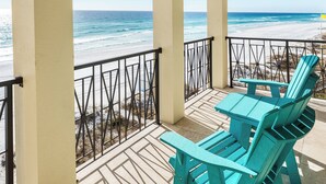 A balcony with a view of the beach, turquoise chairs, and a table. - The Brookie*OnBeach*BeachSvc*Elevator*2Pools (Miramar Beach)