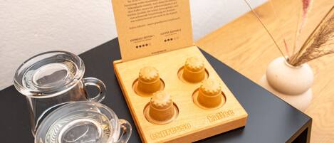A wooden box labeled "espresso" with four compartments, two glass mugs, and a card with text.