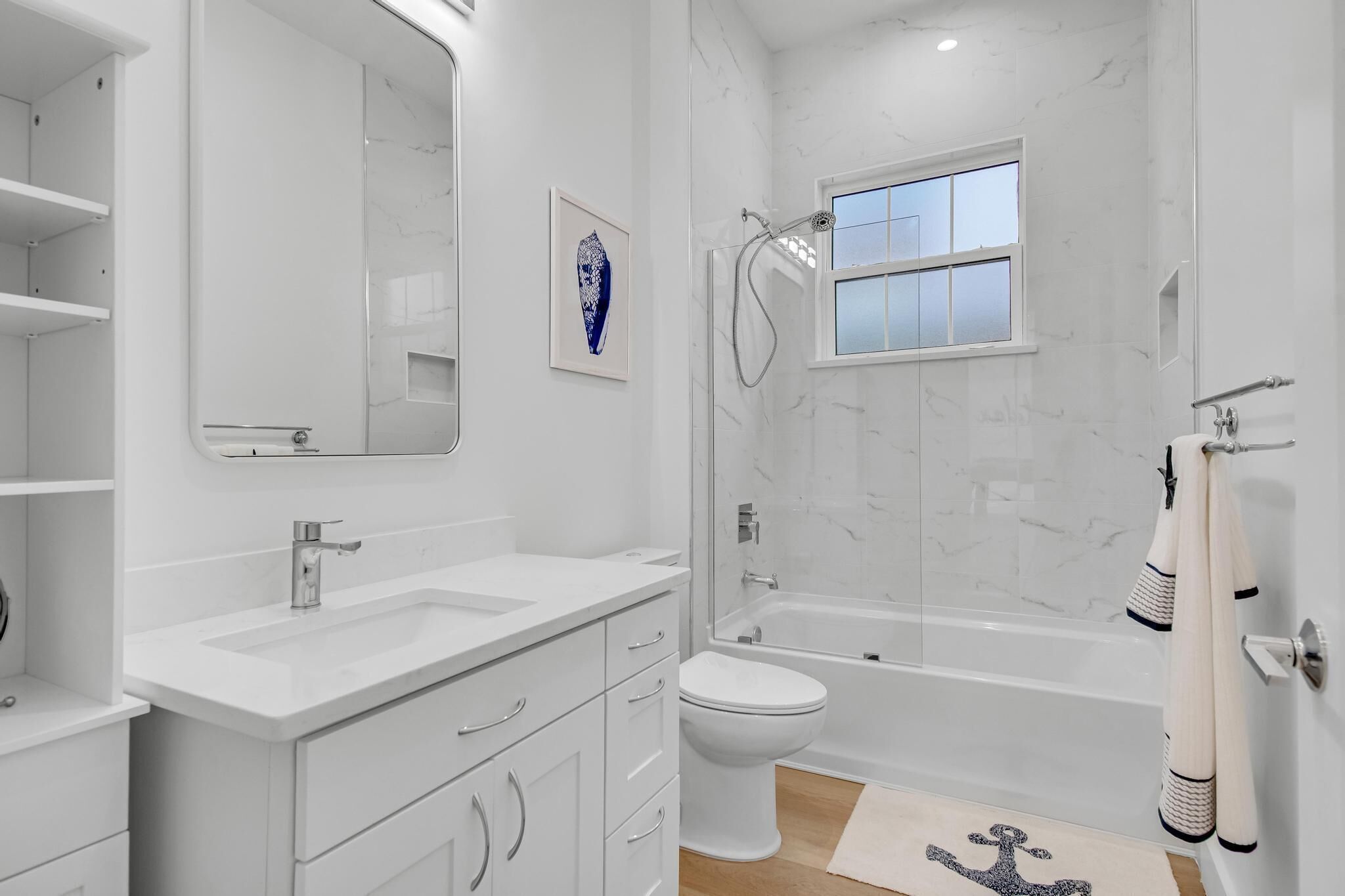 A modern bathroom with a double sink vanity, a toilet, a bathtub, and a shower.